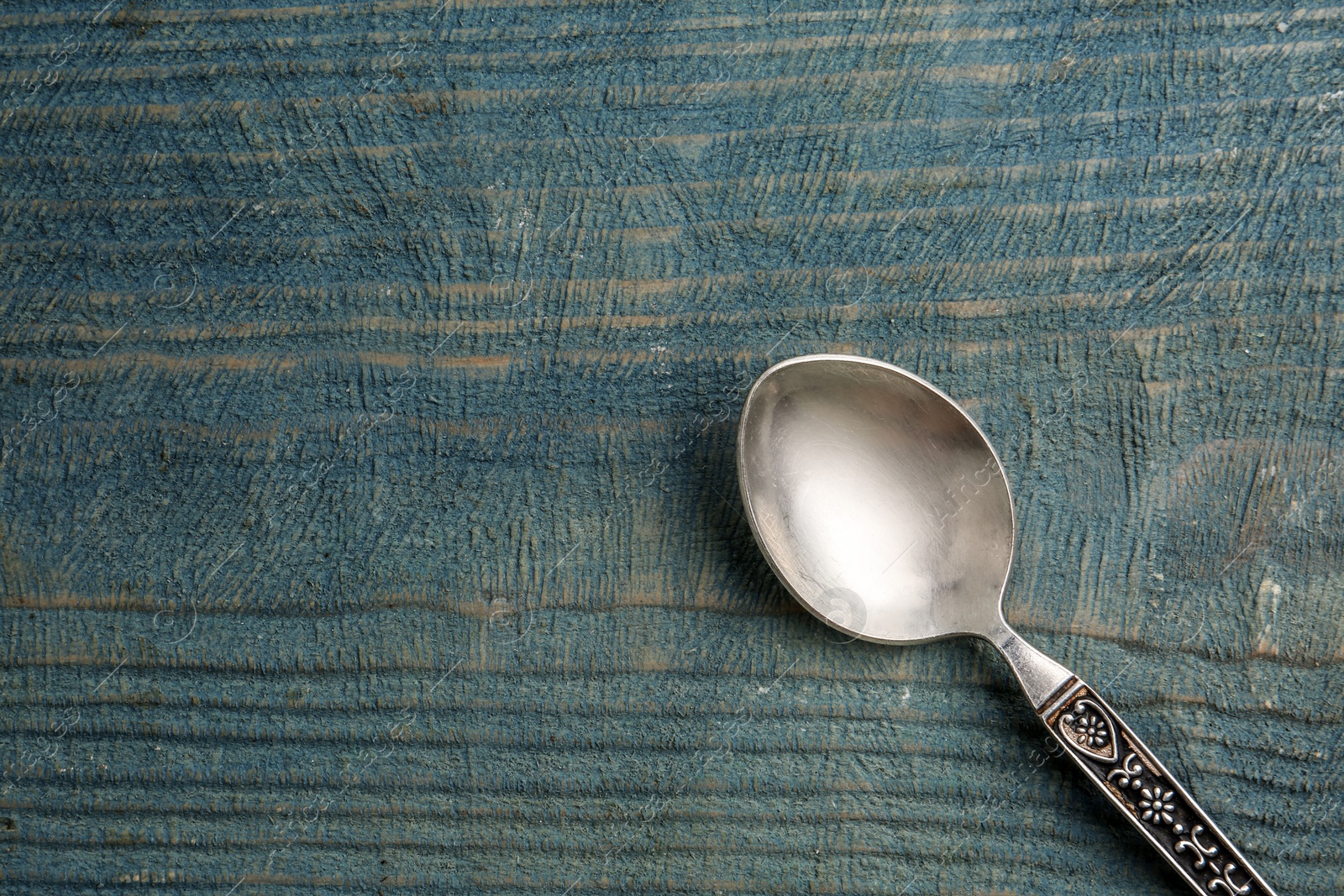 Photo of Clean vintage tea spoon and space for text on wooden background, top view