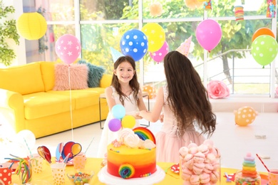 Cute girls playing together at birthday party indoors