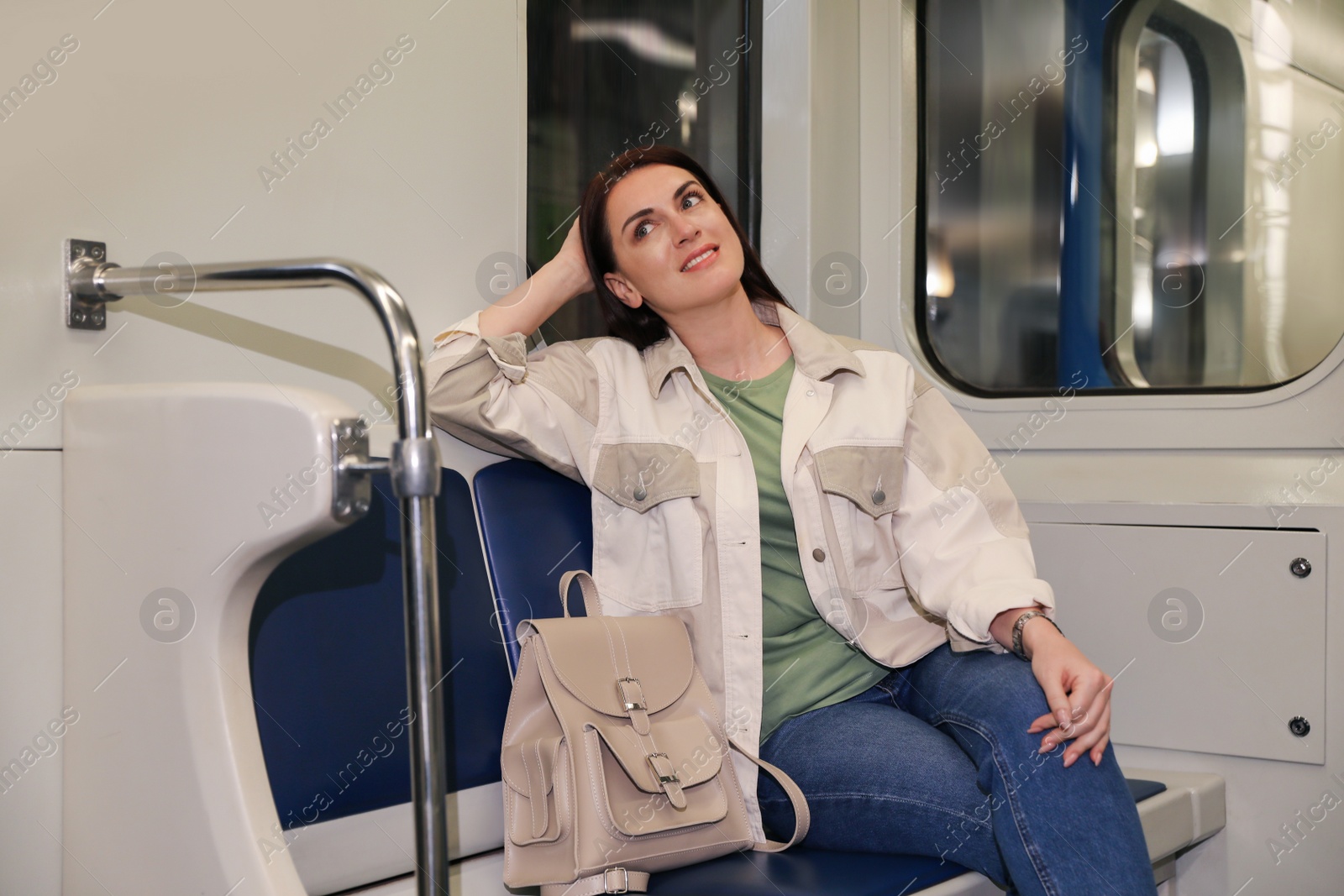 Photo of Beautiful woman with backpack in subway train. Public transport