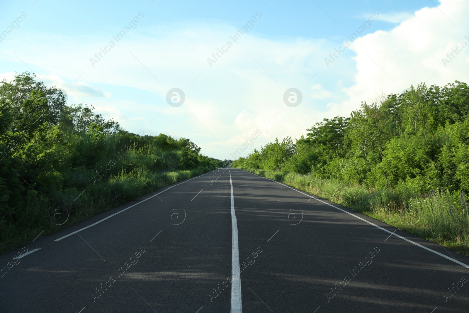 Photo of Asphalt road running through countryside on sunny day