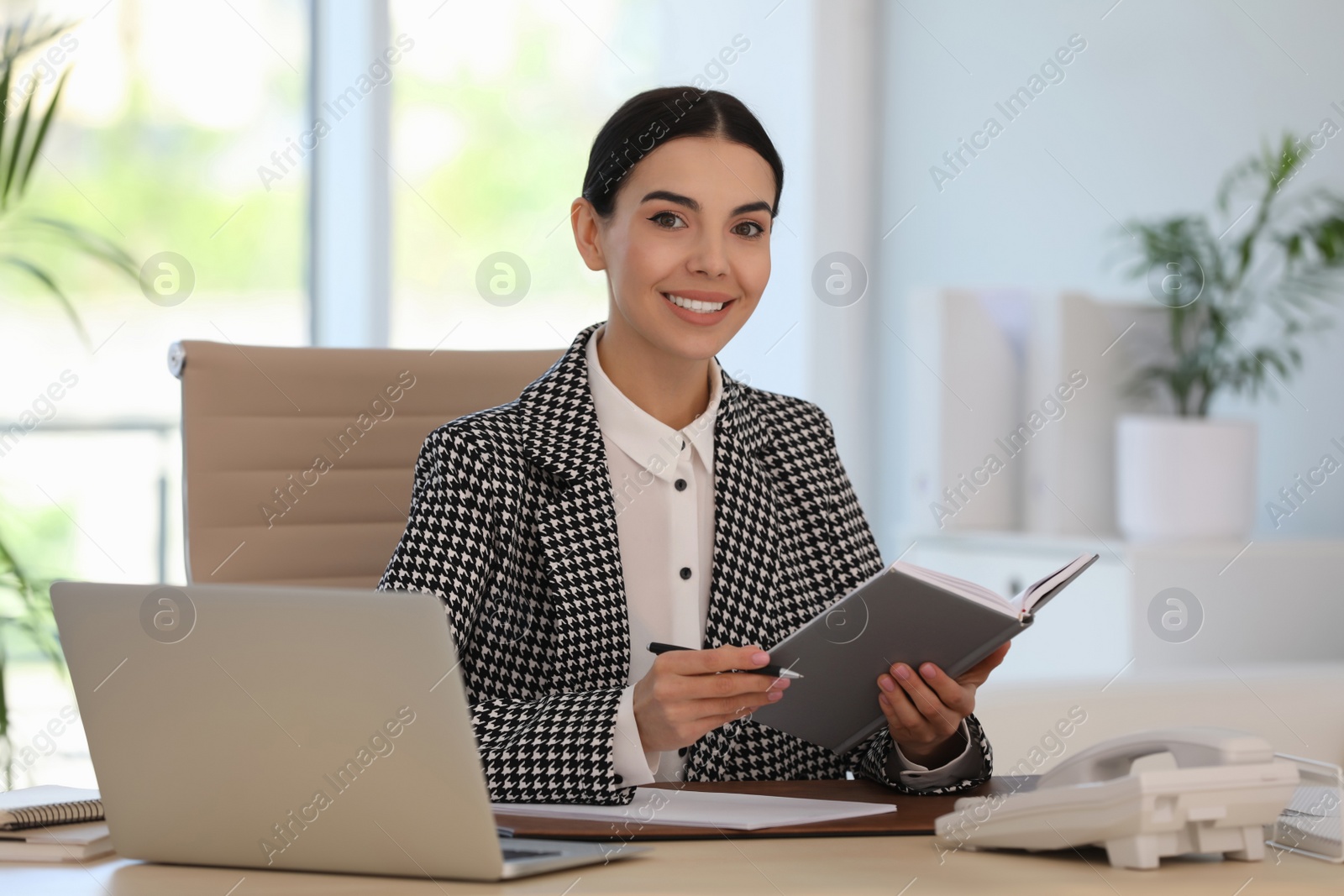 Photo of Secretary working at wooden table in office