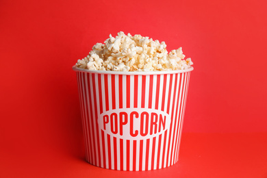 Photo of Tasty fresh pop corn on red background