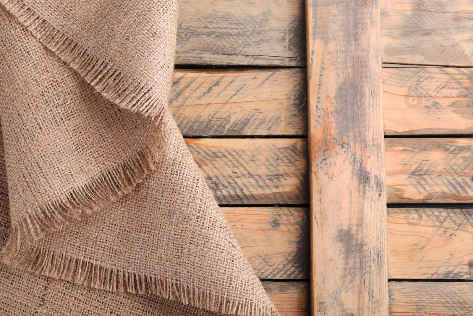 Photo of Beige burlap fabric on wooden table, top view. Space for text