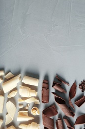 Photo of Yummy chocolate curls and space for text on gray background, top view