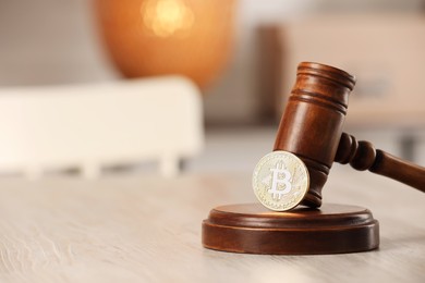 Photo of Law concept. Gavel and bitcoin on wooden table, closeup. Space for text