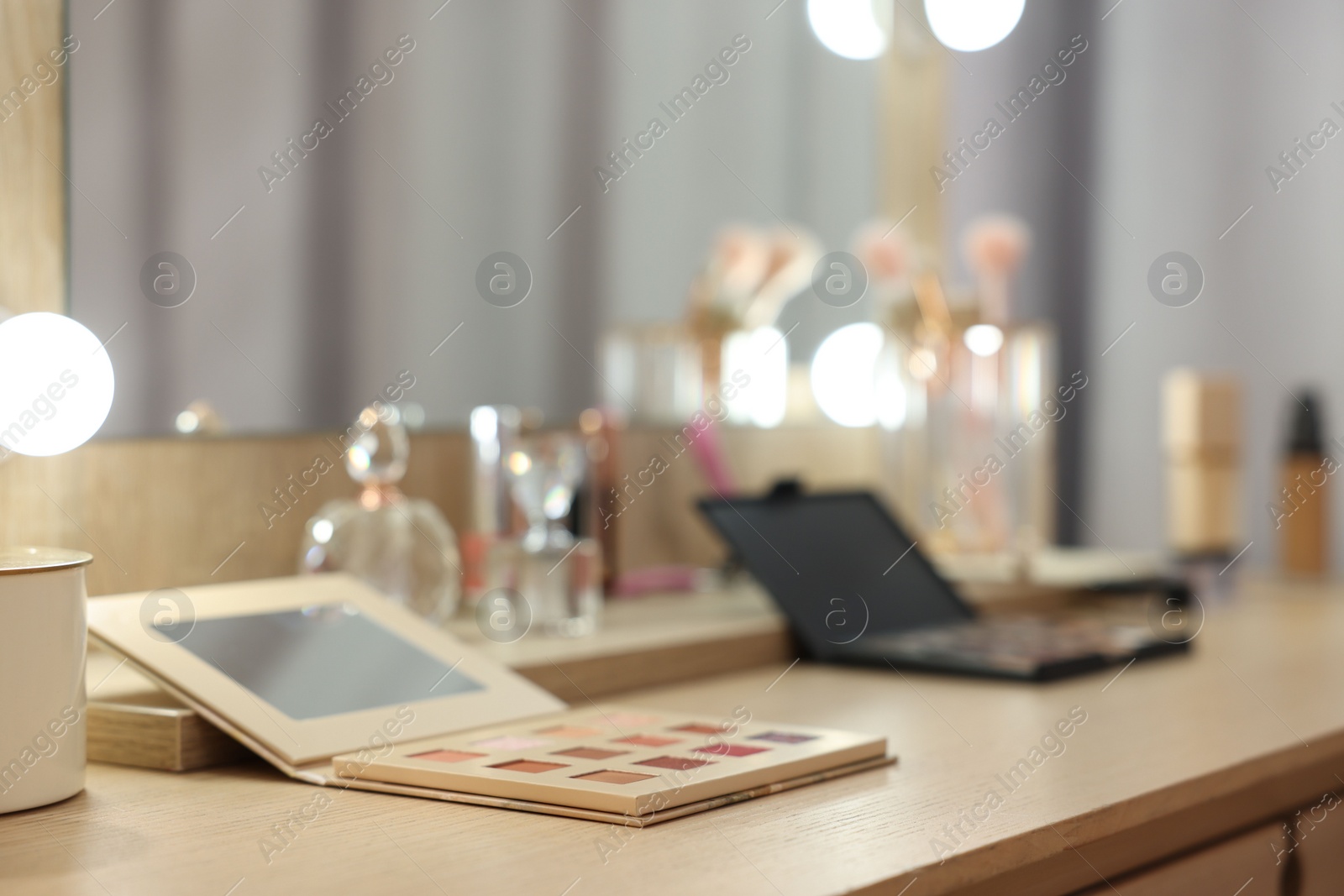 Photo of Cosmetic products on wooden dressing table in makeup room