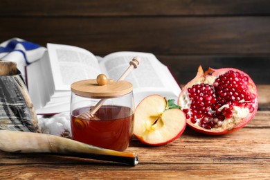 Photo of Honey, pomegranate, apples and shofar on wooden table. Rosh Hashana holiday