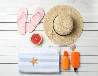 Flat lay composition with grapefruit and beach objects on white wooden background