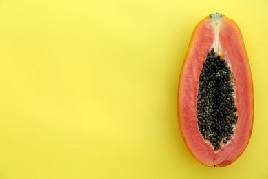 Photo of Half of fresh ripe papaya fruit on light green background, top view. Space for text