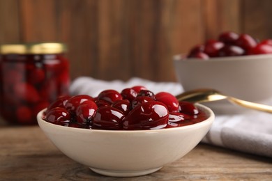 Delicious dogwood jam with berries in bowl on wooden table, closeup