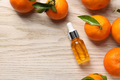 Bottle of tangerine essential oil and fresh fruits on white wooden table, flat lay. Space for text