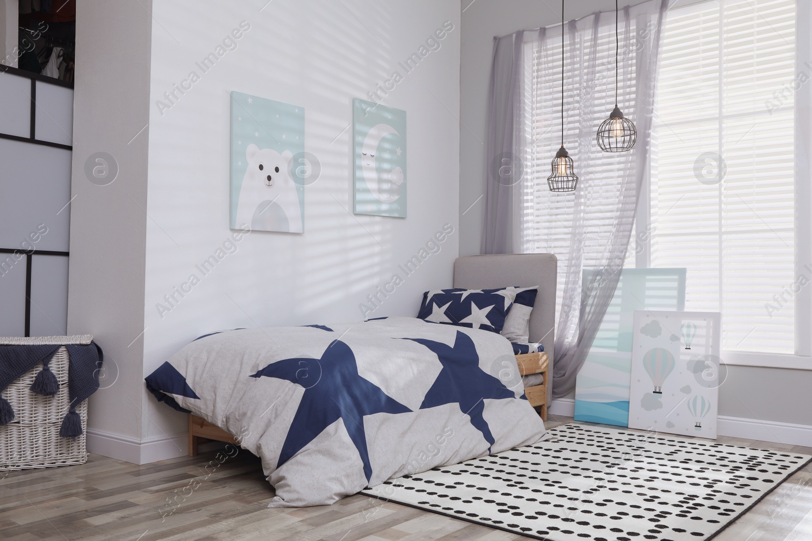 Photo of Bed with stylish linens in children's room. Interior design