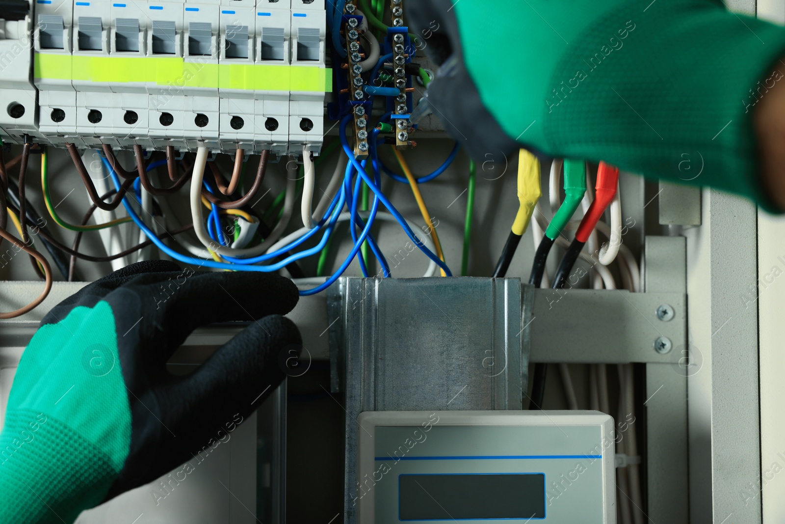 Photo of Electrician repairing fuse box with screwdriver, closeup