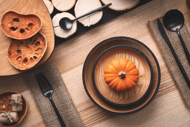 Autumn table setting with pumpkin on wooden background, flat lay