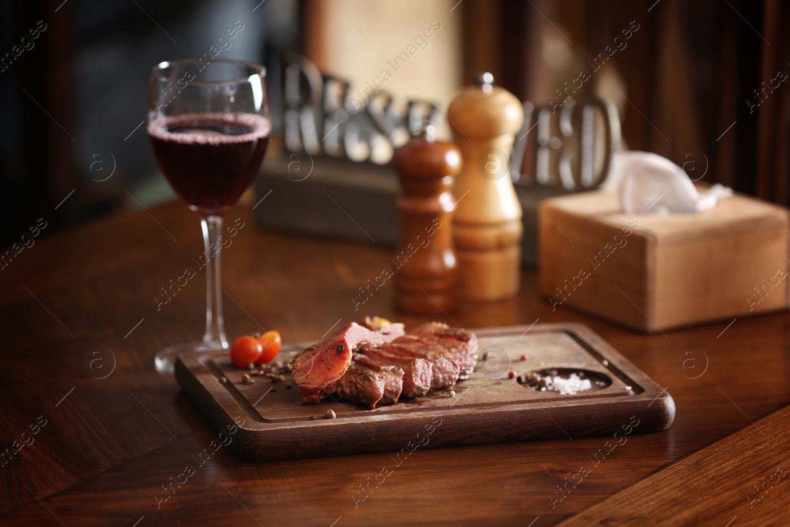 Photo of Tasty roasted meat served on wooden table in restaurant. Cooking food