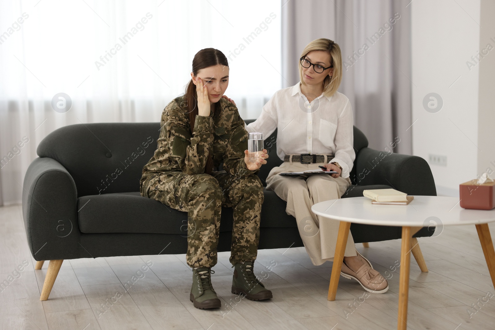 Photo of Psychotherapist working with military woman on sofa in office