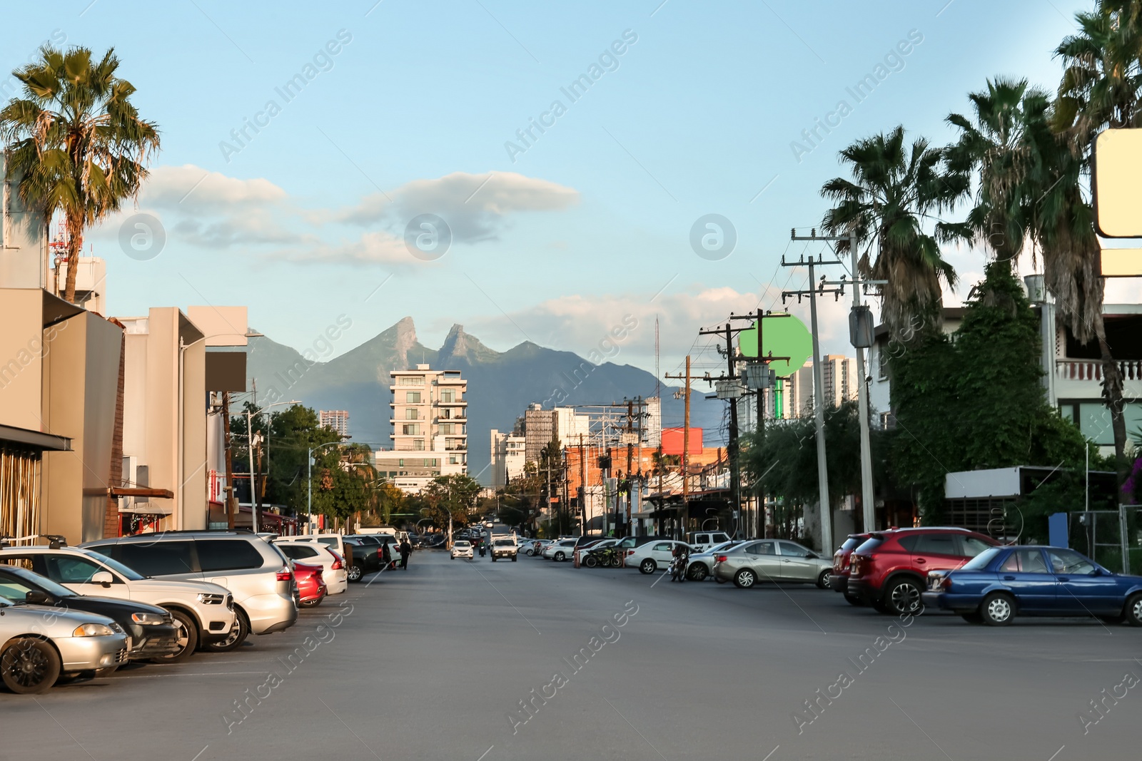 Photo of Picturesque view of city street with cars on road near beautiful buildings