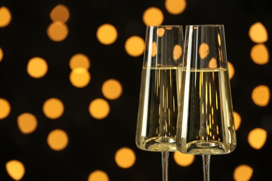 Photo of Glasses of champagne against blurred lights. Space for text