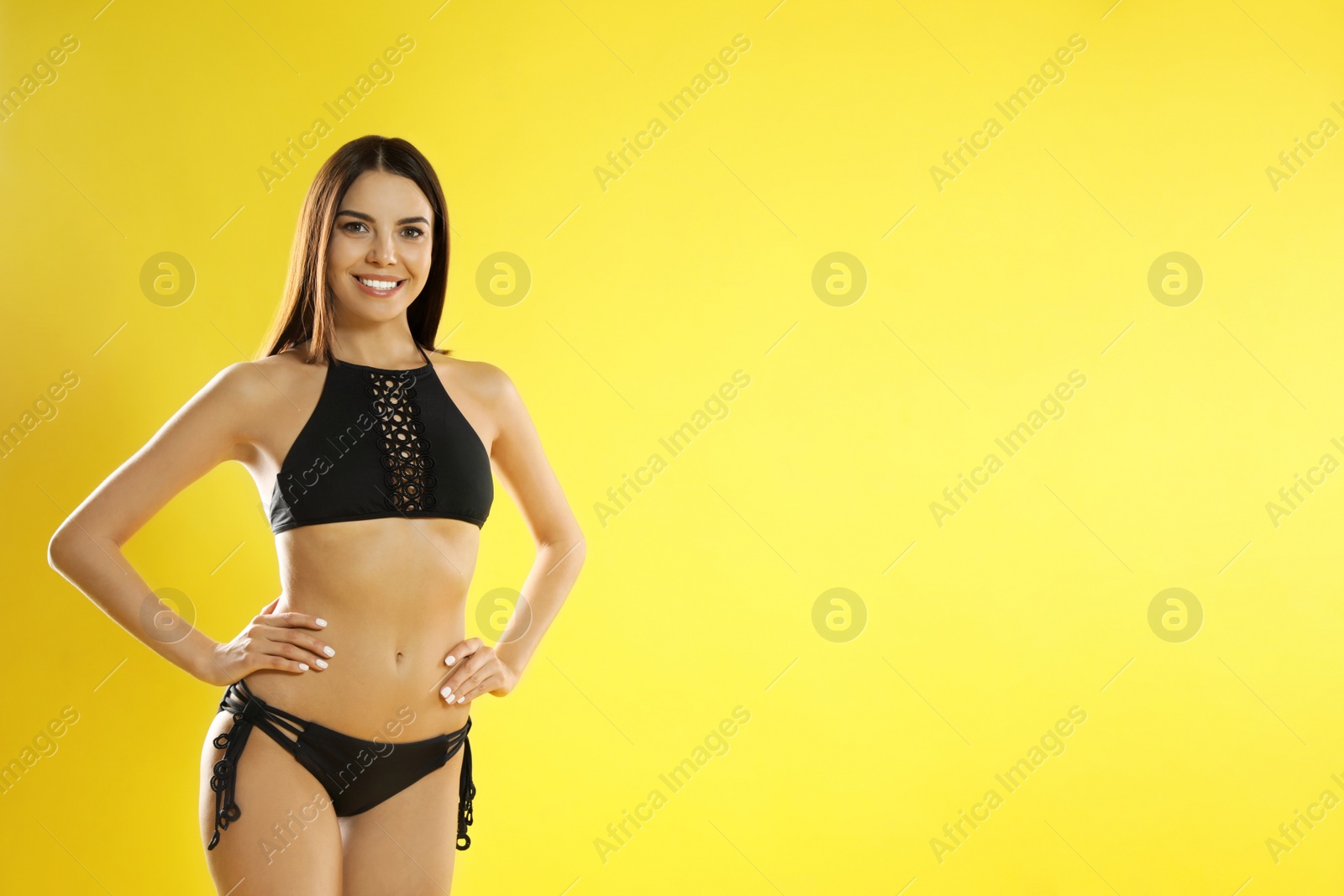 Photo of Portrait of attractive young woman with slim body in swimwear on color background. Space for text