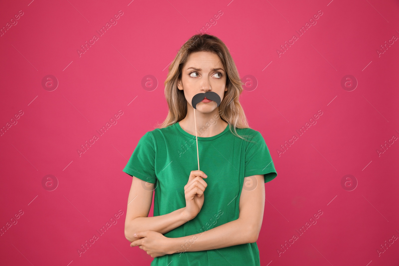 Photo of Young woman with fake mustache on pink background