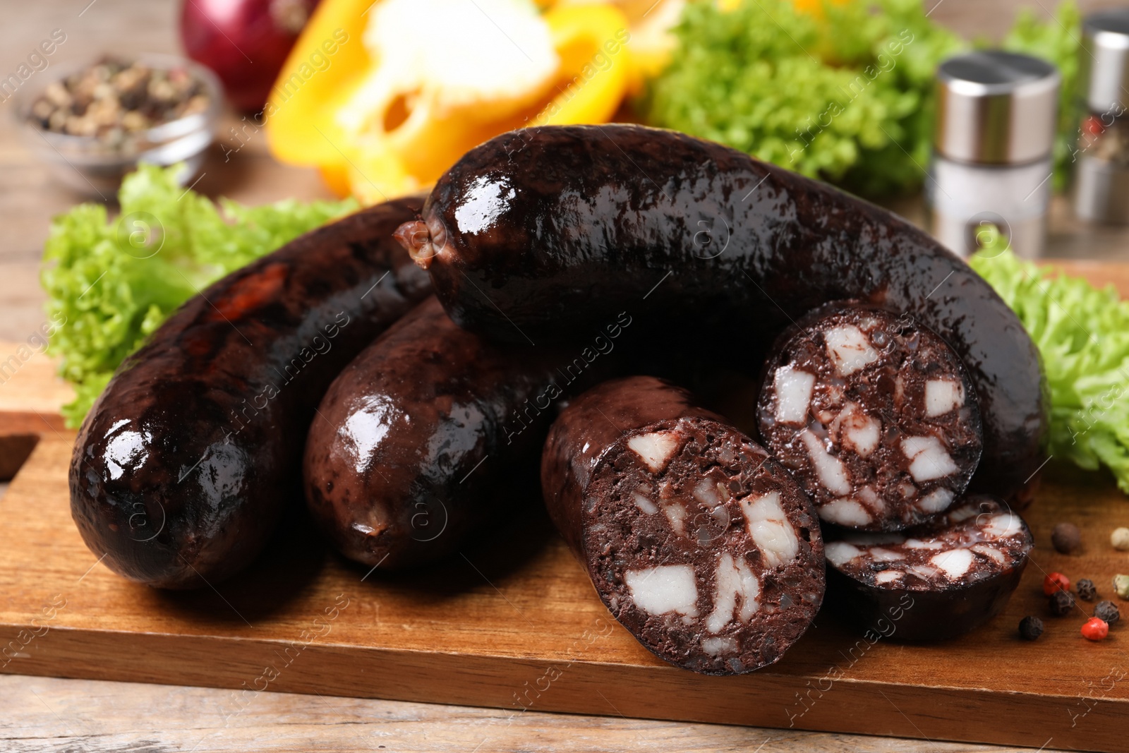 Photo of Tasty blood sausages served on wooden table, closeup