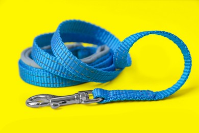 Photo of Blue dog leash on yellow background, closeup