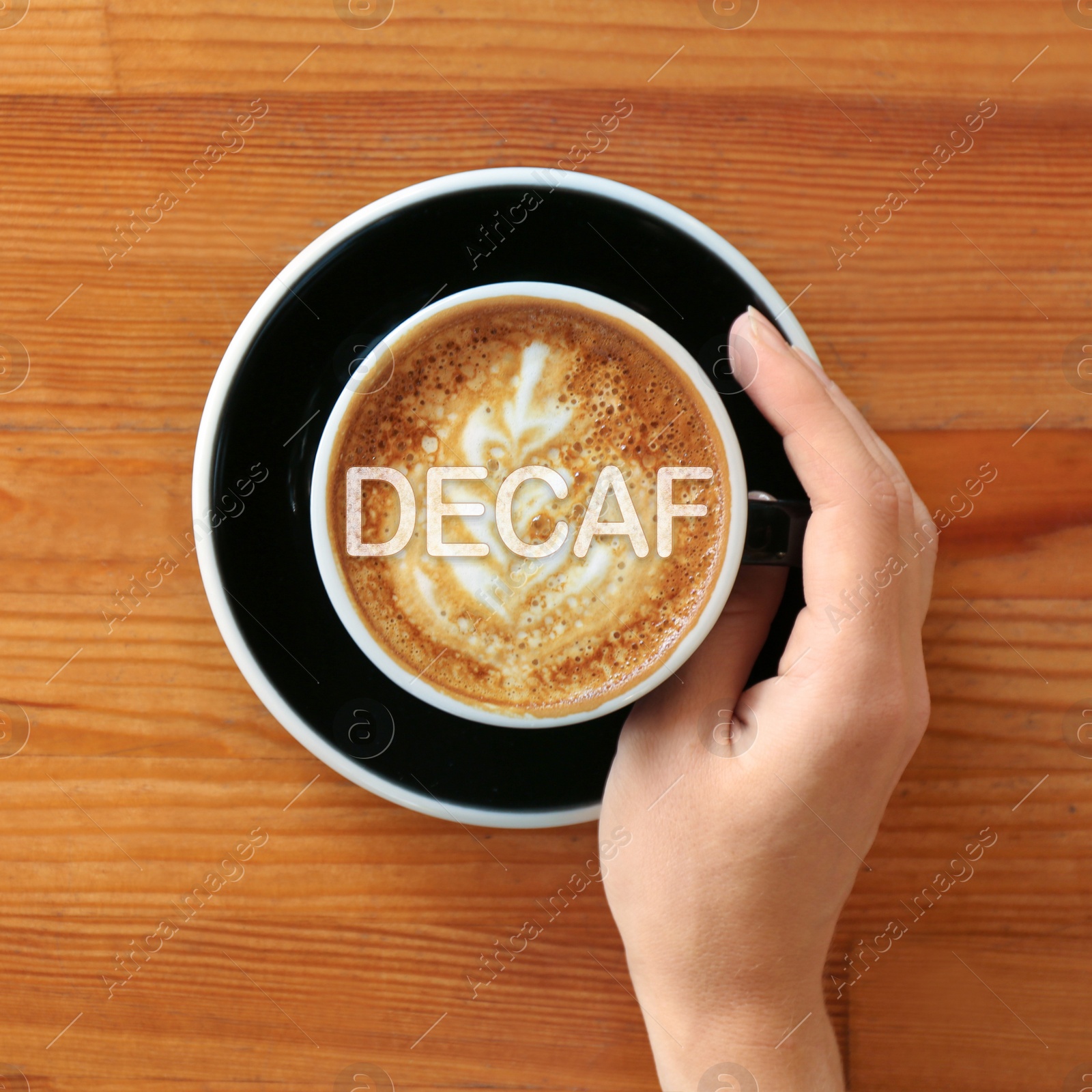 Image of Woman with cup of aromatic decaf coffee at wooden table, top view