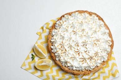 Composition with delicious lemon meringue pie on white table, top view