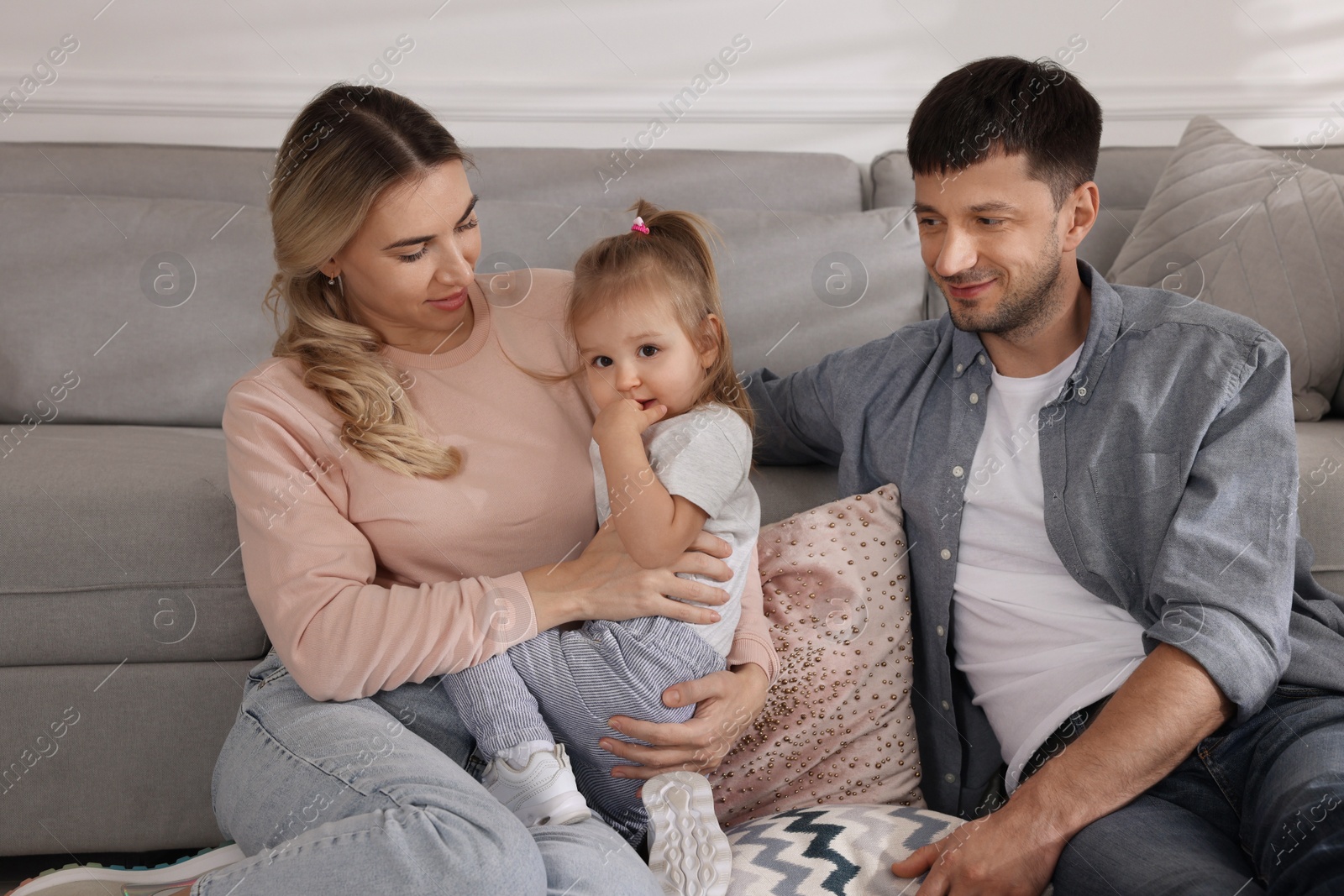 Photo of Family with little daughter spending time together at home