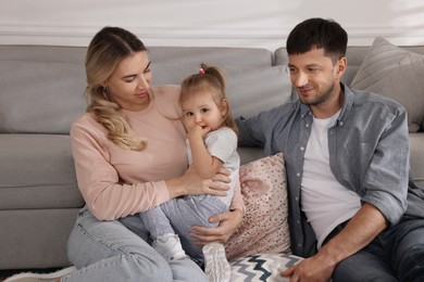 Photo of Family with little daughter spending time together at home