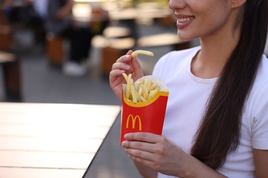 Photo of Lviv, Ukraine - September 26, 2023: Woman with McDonald's french fries outdoors, closeup. Space for text