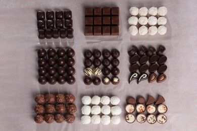 Many delicious chocolate candies on table, flat lay. Production line