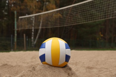 Colorful volleyball ball on sand court, closeup