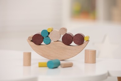 Photo of Wooden pieces of balancing game on white table indoors, closeup. Educational toy for motor skills development