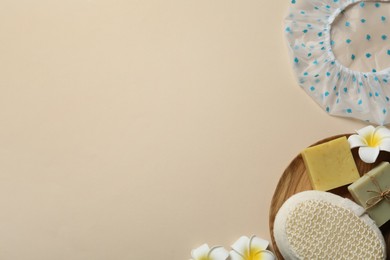 Photo of Flat lay composition with shower cap and toiletries on beige background. Space for text
