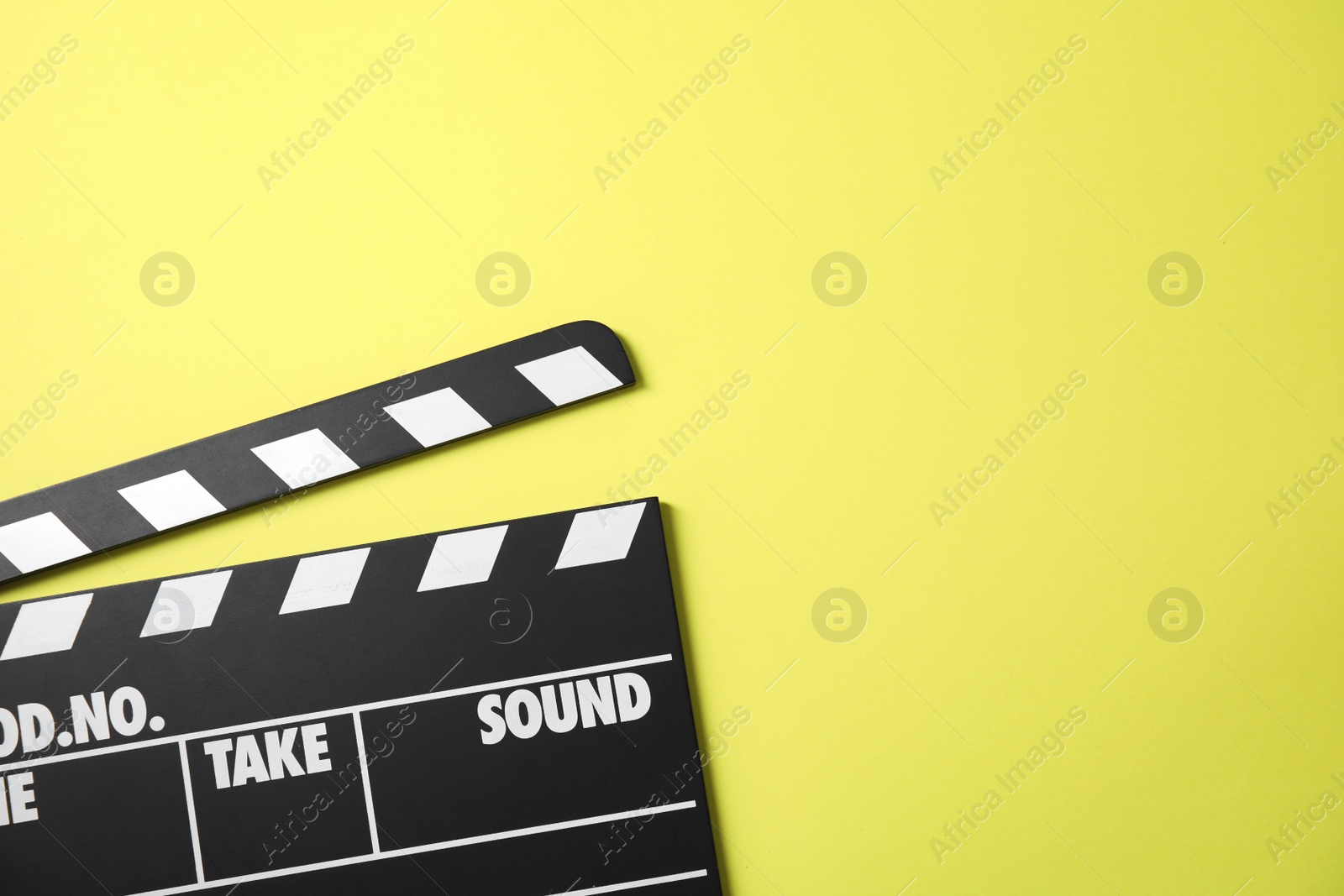 Photo of Clapperboard on color background, top view with space for text. Cinema production