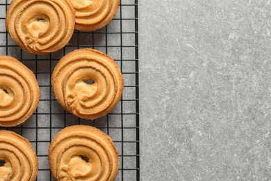 Photo of Baking grid with Danish butter cookies on grey table, top view. Space for text