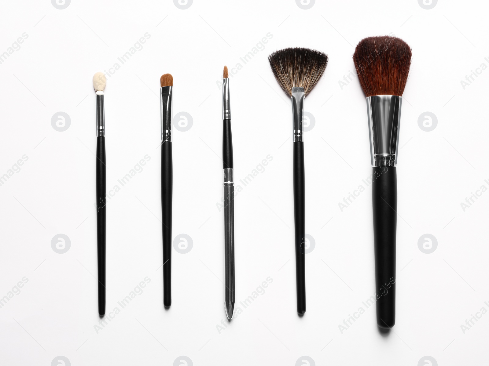 Photo of Different makeup brushes on white background, flat lay