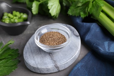 Photo of Bowl of celery seeds on grey table, closeup