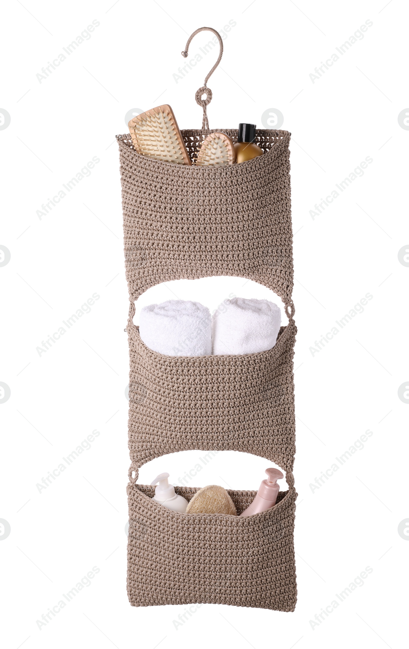 Photo of Stylish knitted organizer with toiletries and towels on white background. Bath accessory