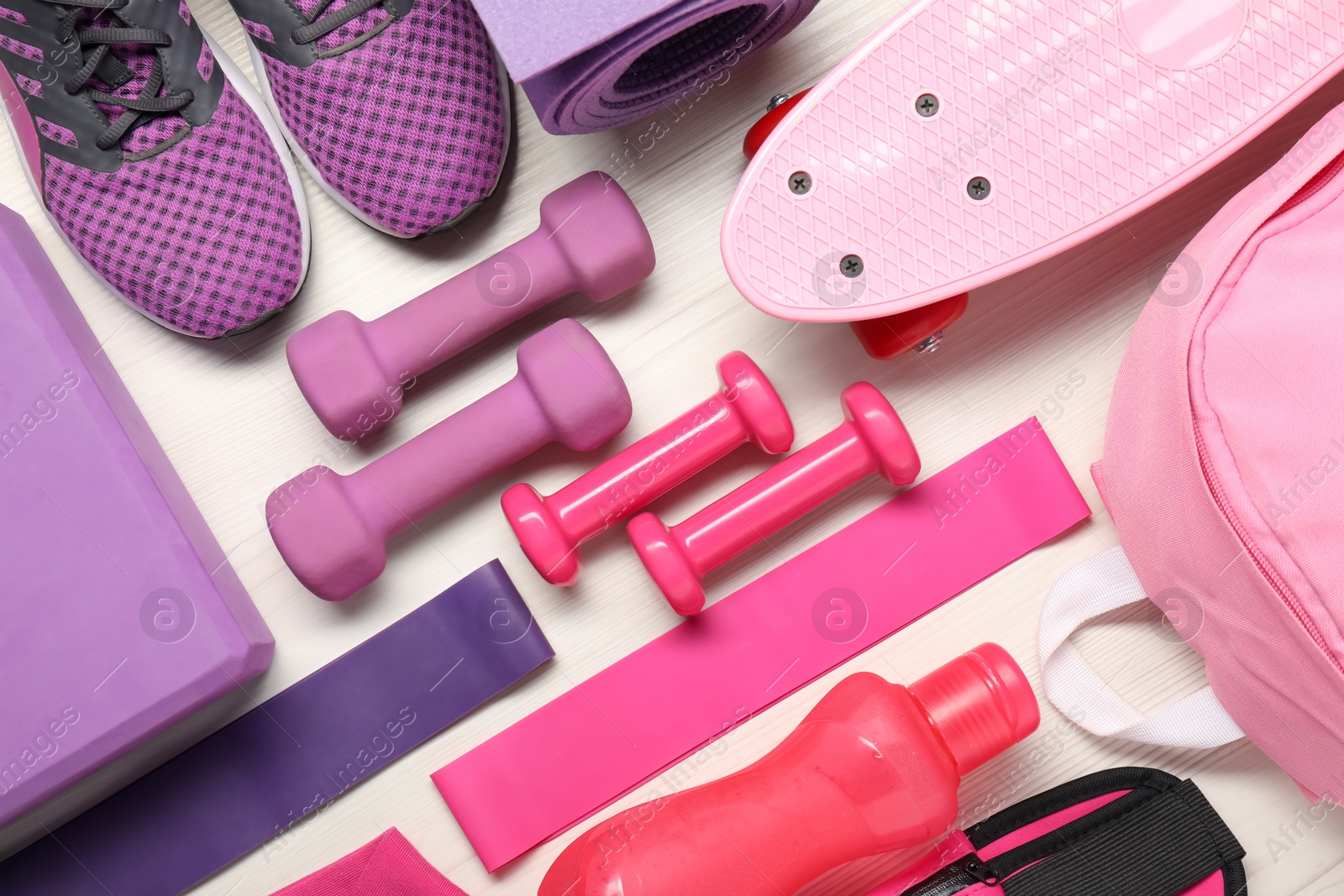 Photo of Different sports equipment on white wooden table, flat lay