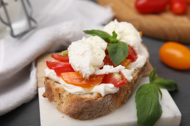 Photo of Delicious sandwich with burrata cheese and tomatoes on table, closeup