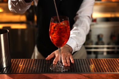 Bartender making fresh alcoholic cocktail at bar counter, closeup
