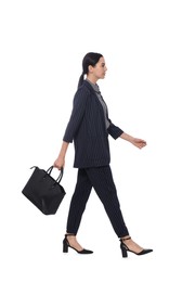 Photo of Young businesswoman with leather bag walking on white background
