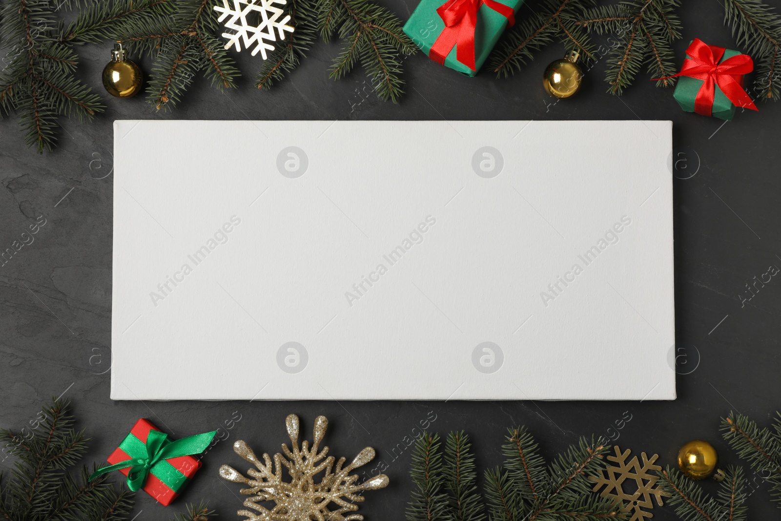 Photo of Flat lay composition with blank canvas and Christmas decor on black background. Mockup for design