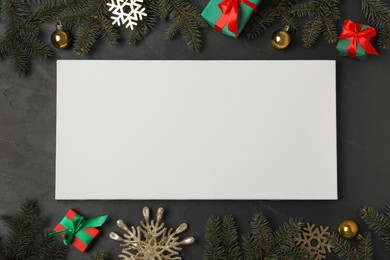 Photo of Flat lay composition with blank canvas and Christmas decor on black background. Mockup for design