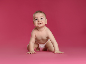 Cute little baby in diaper on pink background