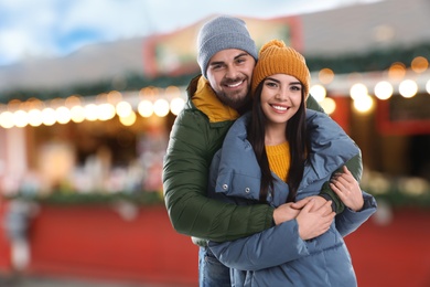 Image of Happy couple at Christmas fair, space for text. Bokeh effect