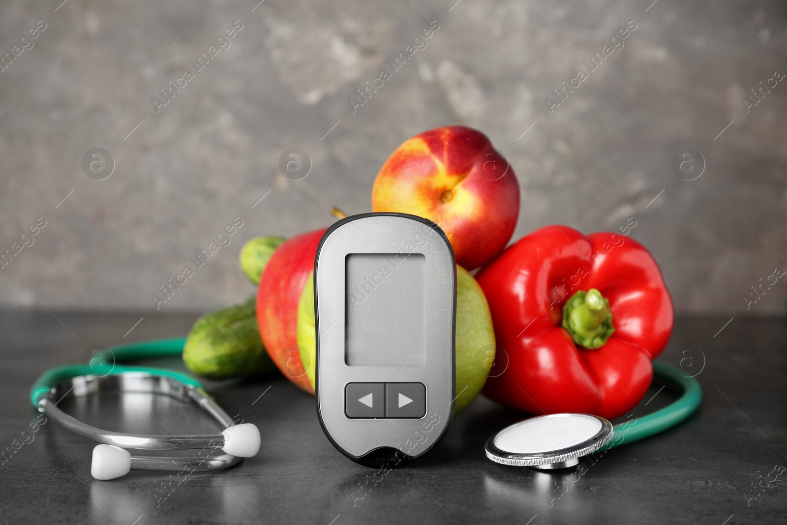 Photo of Digital glucometer, stethoscope, fruits and vegetables on table. Diabetes concept