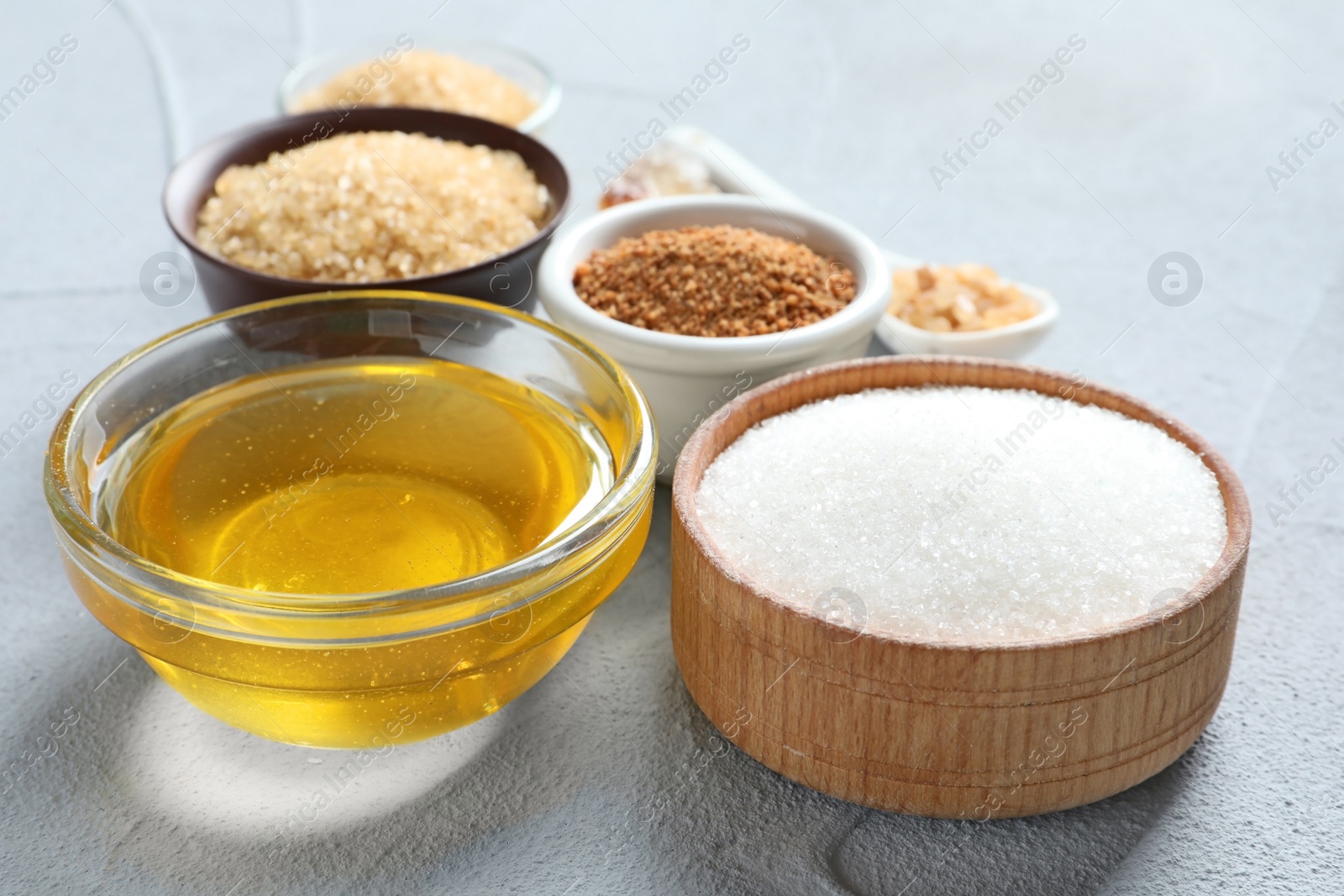 Photo of Various kinds of sugar and honey on light background